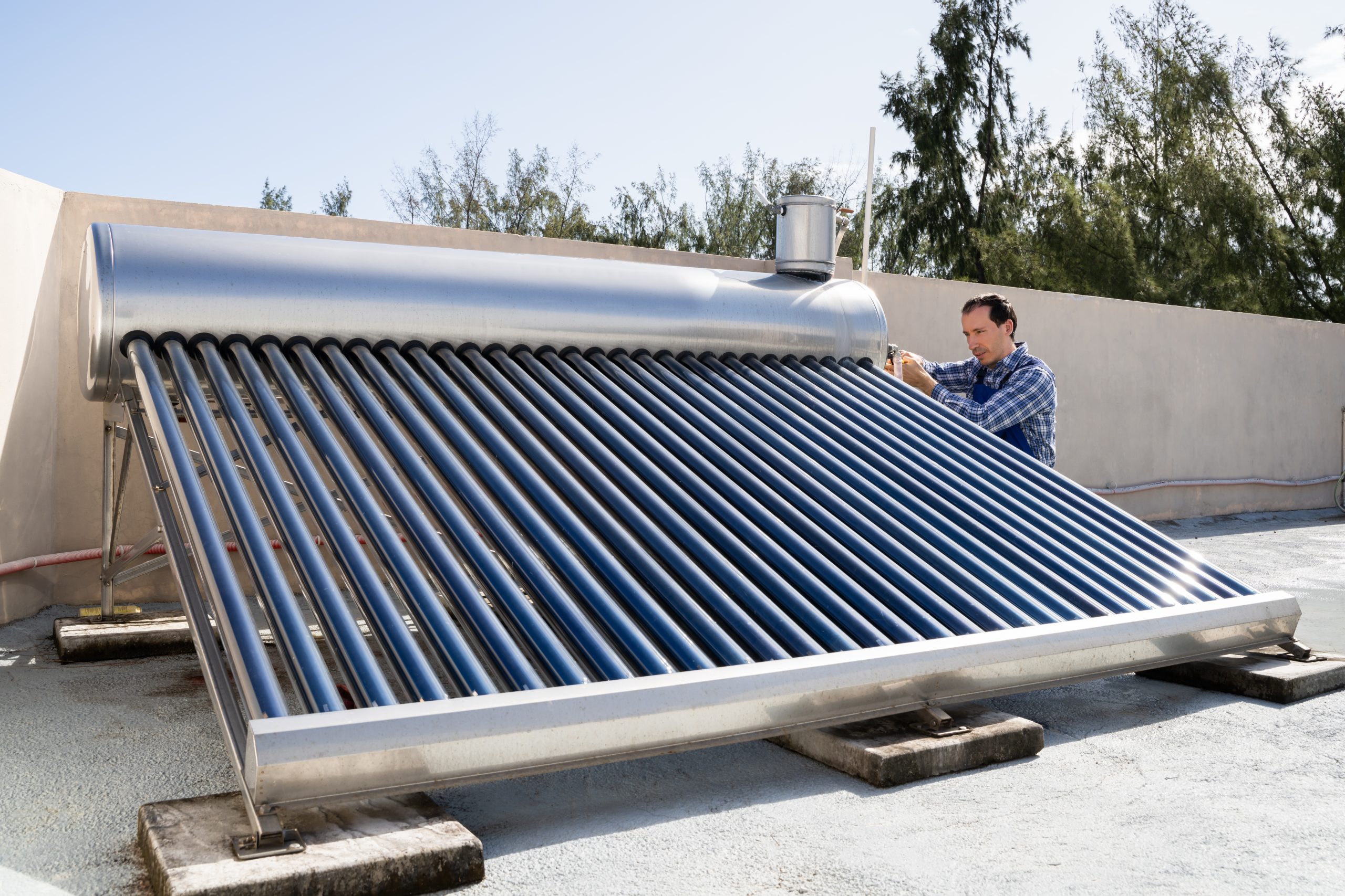 Homme installant un chauffe-eau solaire